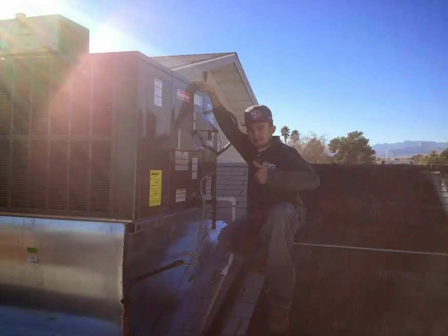HVAC technician performing AC Tune-Up on a rooftop unit in Painesville